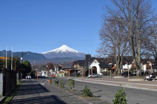una montaña al fondo de un pueblo con una calle en Departamento Pucon, en Pucón