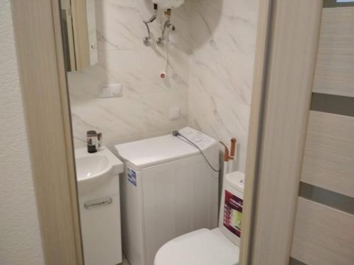 a bathroom with a white toilet and a sink at Smart-House Smart kvartira s kukhnei vozle metro. in Kyiv
