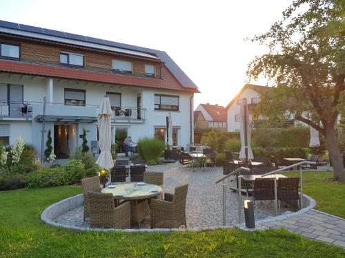 a patio with a table and chairs in front of a building at Landhotel Sonnenhalde in Bad Boll