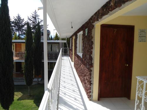 a staircase leading to a house with a brown door at Posada Dos Hermanos in Huasca de Ocampo