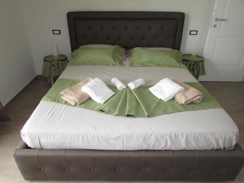 a large bed with towels and pillows on it at B&B Bellavista in Tavullia