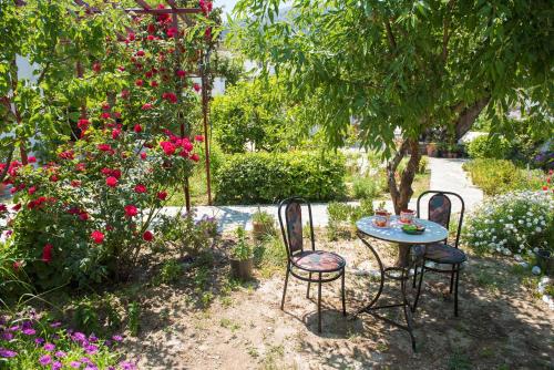 a table and chairs in a garden with flowers at Kipos in Apollonia