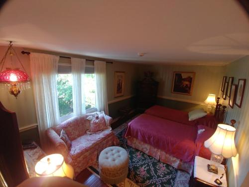 a bedroom with a bed and a couch and a window at TwiningRetreat in Niagara on the Lake