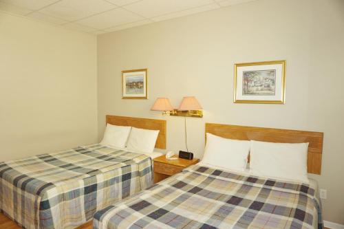 a hotel room with two beds and a telephone at Motel Casino in Gatineau