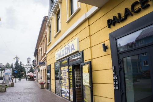 a yellow building with a sign on the side of it at Premium Apartment Centrum in Poprad