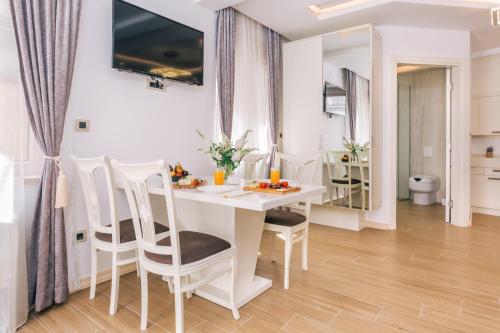 a kitchen and dining room with a white table and chairs at Splendido MB Apartments in Tivat