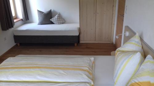 a bedroom with two beds with pillows and a window at Bauernhof Residence Hausergut with Ortler views, central and quiet position in Sluderno