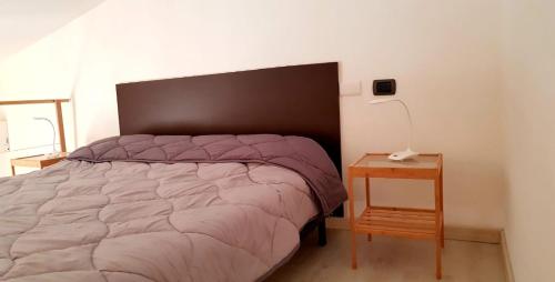 um quarto com uma cama e uma mesa com um candeeiro em Mini Loft Porto Torres em Porto Torres