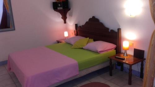 ein Schlafzimmer mit einem Bett und zwei Lampen auf einem Tisch in der Unterkunft Appartement SunBurst in Sainte-Anne