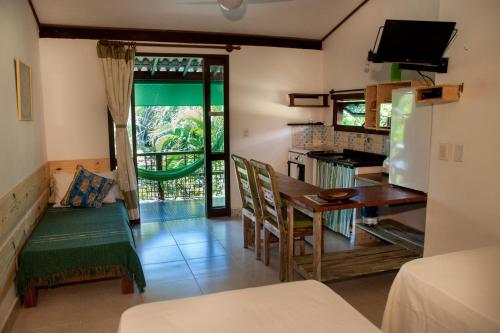 uma cozinha e sala de jantar com mesa e cadeiras em Casa Verde Apart - Aptos e Casa Residencial na Praia do Forte