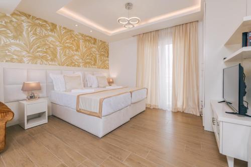 a white bedroom with a bed and a television at Splendido MB Apartments in Tivat