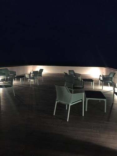 a row of chairs and tables in a dark room at Fly Decó Hotel in Lido di Ostia