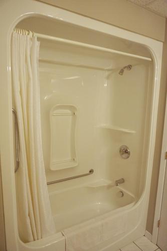 a white shower with a shower curtain in a bathroom at Motel Casino in Gatineau
