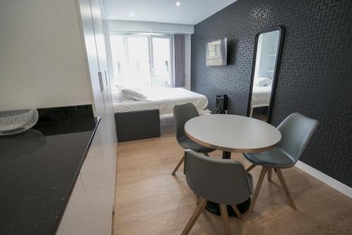 ビアリッツにあるBellevue 766 Biarritzのテーブル、椅子、ベッドが備わる小さな客室です。