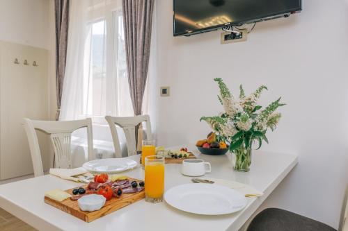 a white table with a plate of food on it at Splendido MB Apartments in Tivat