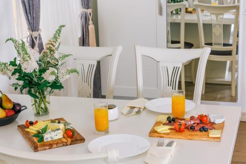 a white table with two plates of food and orange juice at Splendido MB Apartments in Tivat