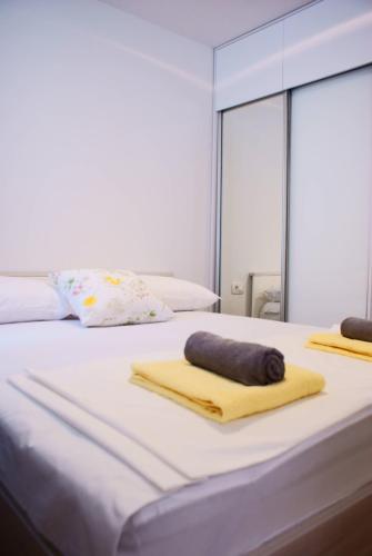 a bedroom with two beds with towels and a mirror at Luxury Apartment Luka in Omiš