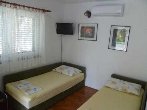 a small room with a bed and a tv at Vesna Pag Potočnica in Borovići