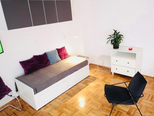 een slaapkamer met een bed met 2 stoelen en een dressoir bij West vibes apartment in Zagreb