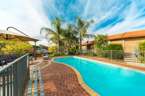 a swimming pool in front of a house at Hume Country Motor Inn in Albury