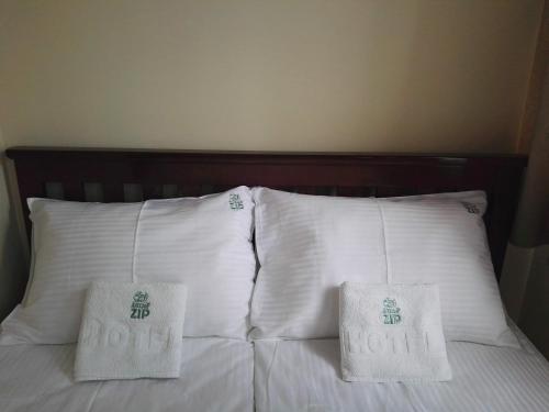 two pillows on top of a bed with white pillows at Apartments&Camping ZIP in Kremna