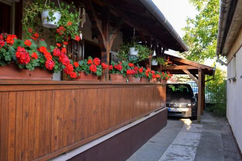 a fence with flowers on it with a car in the background at Varga Vendégház in Tiszakécske