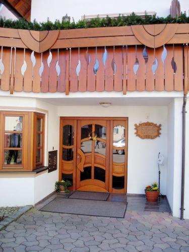 ein Gebäude mit einer Holztür und einem Balkon in der Unterkunft Gästehaus Waldner in Alfdorf