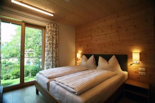 a bedroom with a large bed with a large window at Apart-Faakersee in Drobollach am Faaker See