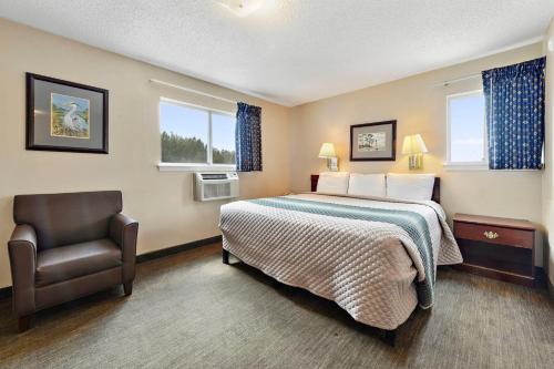 a hotel room with a bed and a chair at Siegel Select Gautier in Gautier