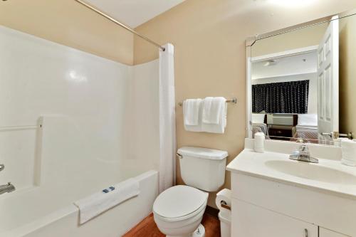 La salle de bains est pourvue de toilettes, d'un lavabo et d'un miroir. dans l'établissement Siegel Select Gautier, à Gautier