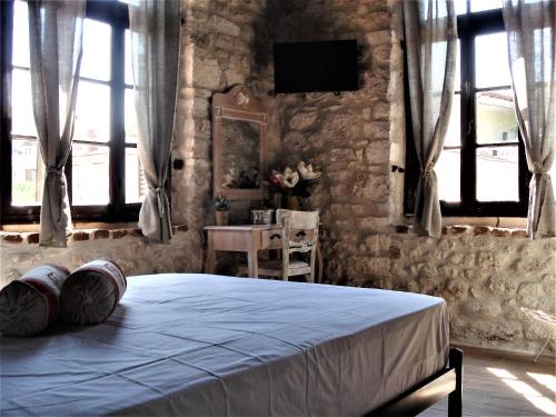 a bedroom with a bed and a table and windows at Elisw in Afitos