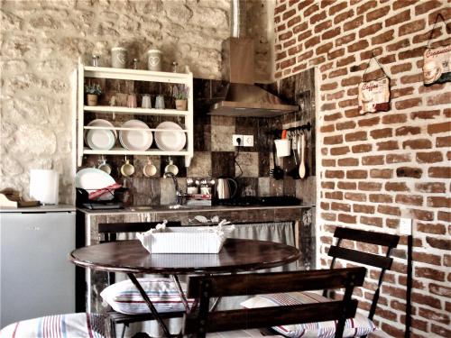 a kitchen with a table and a brick wall at Elisw in Afitos