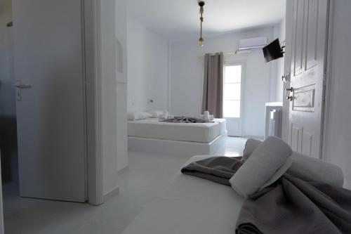 a white room with a bed and a chair at Teoria Paros - Matsas Windmill in Naousa