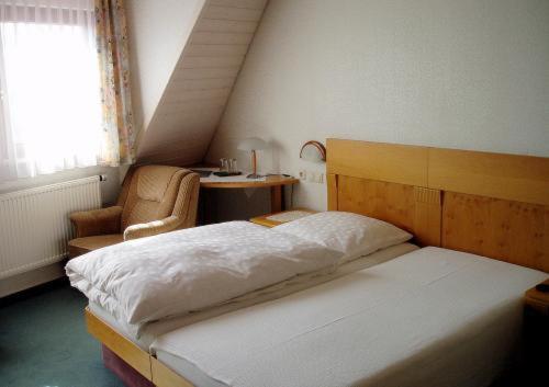 1 dormitorio con cama, silla y escritorio en Gästehaus Waldner en Alfdorf