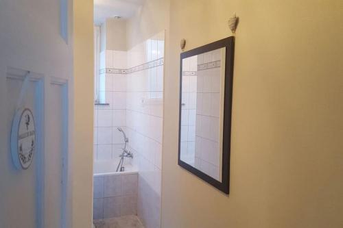 La salle de bains est pourvue d'un miroir et d'une baignoire. dans l'établissement Le yellow, à La Bresse