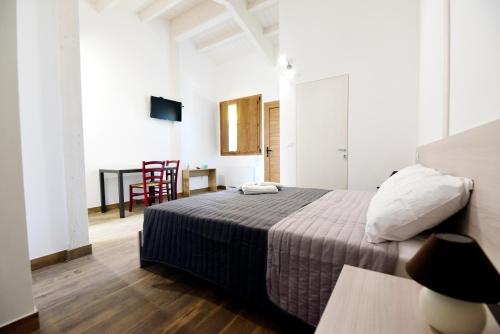 a bedroom with a bed and a table with a chair at La Cerqua in Arcevia