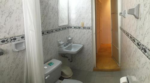 a bathroom with a toilet and a sink at Casa De La Luz - Guesthouse in Tlacotalpan