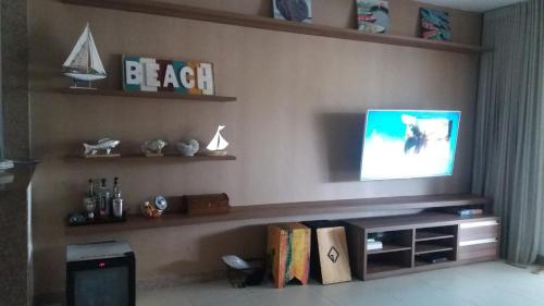 a living room with a flat screen tv on a wall at Vila das Flores ( vilage) in Itacimirim