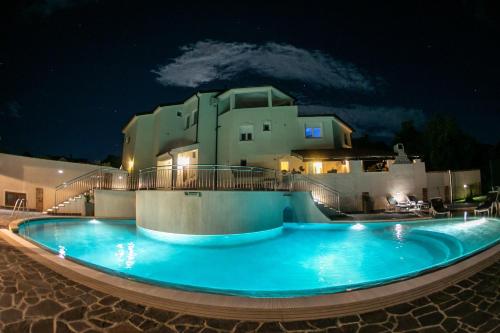 a swimming pool in front of a house at night at Amela in Pula