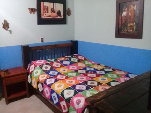 a bed with a colorful comforter in a bedroom at Hotel Atenas Jericó in Jericó