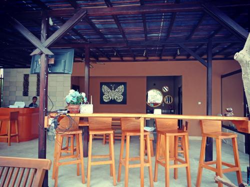 a kitchen with a bar with wooden stools at ZiFa Mandalika in Kuta Lombok