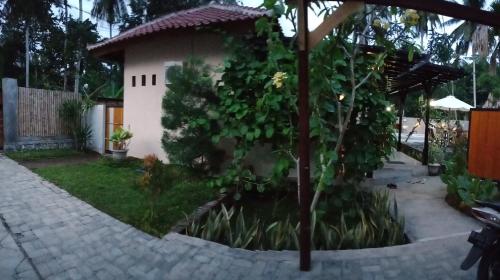 a small house with a tree in the yard at ZiFa Mandalika in Kuta Lombok