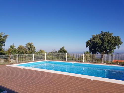 a swimming pool in front of a fence at Luar do Cano in Monchique