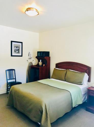 a bedroom with a large bed and a chair at Bella Capri Inn and Suites in Camarillo