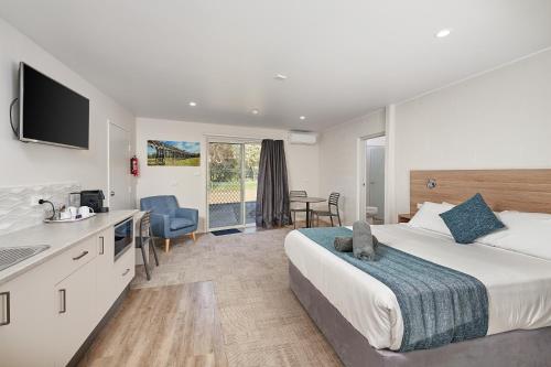 a hotel room with a king sized bed and a kitchen at Gundagai Tourist Suites in Gundagai