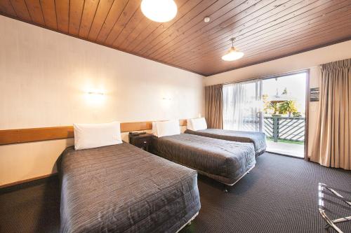 Lakeland Resort Taupo tesisinde bir odada yatak veya yataklar
