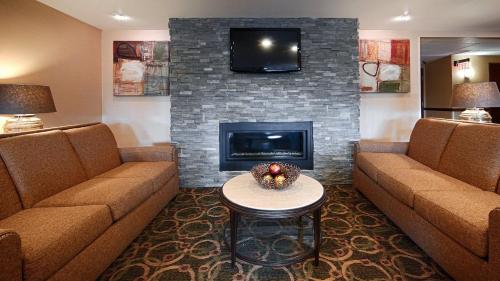 a living room with two couches and a fireplace at Comfort Inn & Suites Copley Akron in Copley