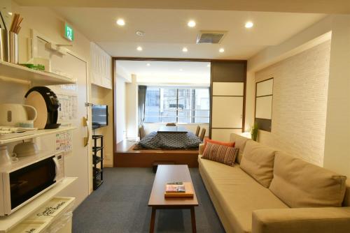 a living room with a couch and a table at KandoStay EAST TORANOMON in Tokyo