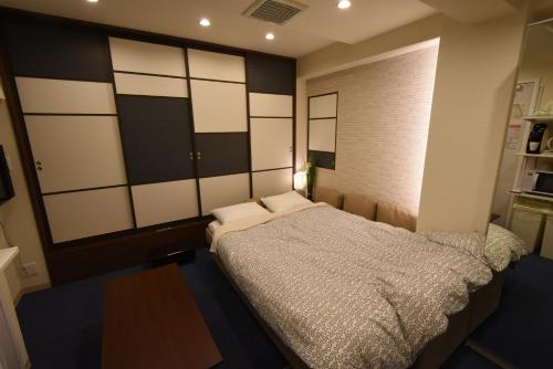 a bedroom with a large bed in a room at KandoStay EAST TORANOMON in Tokyo