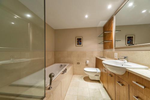 a bathroom with a tub and a sink and a toilet at QV Stays Peace and Style in the Iconic Metropolis in Auckland